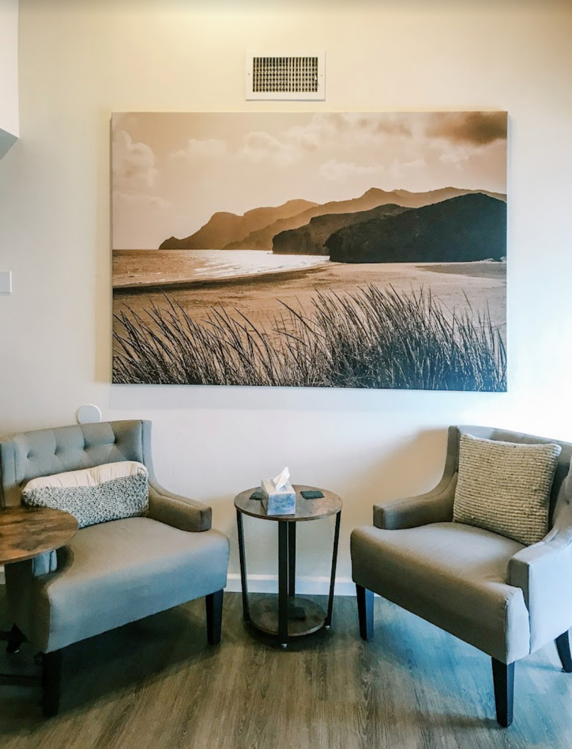 Waiting area with seating and coastal artwork